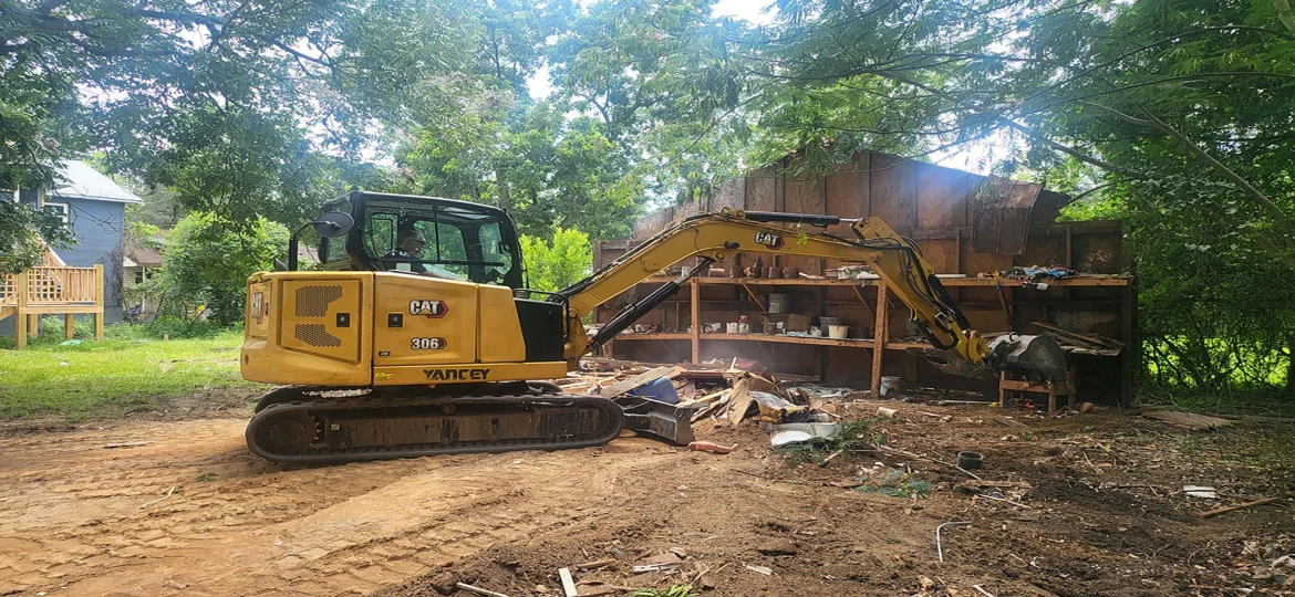 Excavator tearing down a dilapidated storage building for demolition
